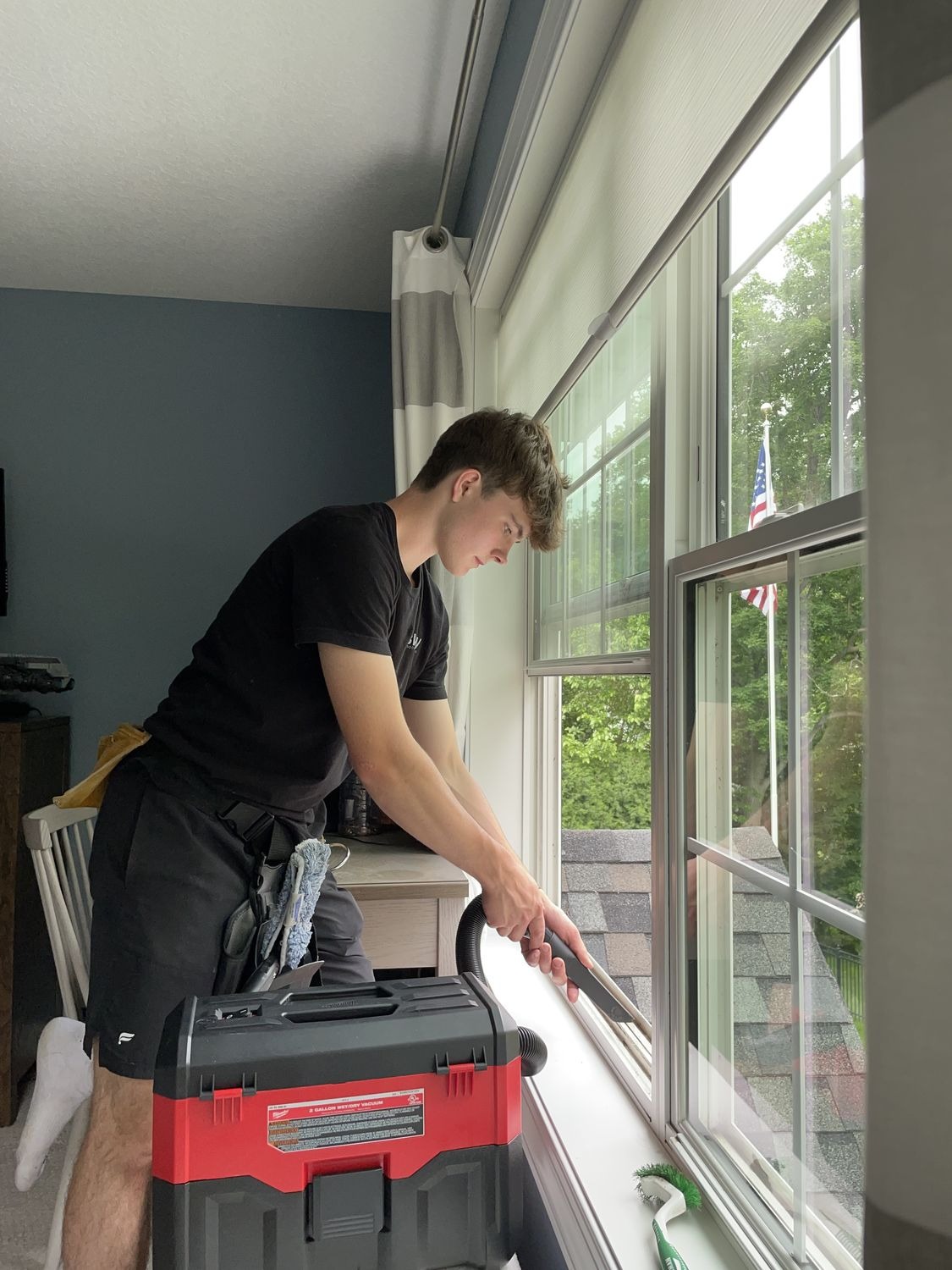 Technician vacuuming a window track with a wet/dry vacuum